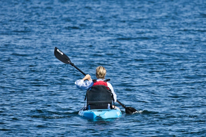 a person in a kayak paddling on the water
